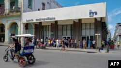 Personas hacen fila en una sucursal del Banco Metropolitano.
