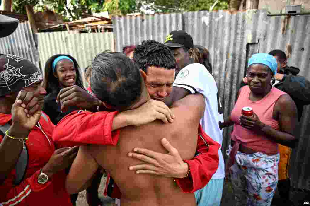 Marlon Brando Díaz (C), encarcelado por su participación en las protestas antigubernamentales de julio de 2021, saluda a sus familiares después de ser liberado de la prisión en el barrio de Guinera en La Habana el 16 de enero de 2025. YAMIL LAGE / AFP