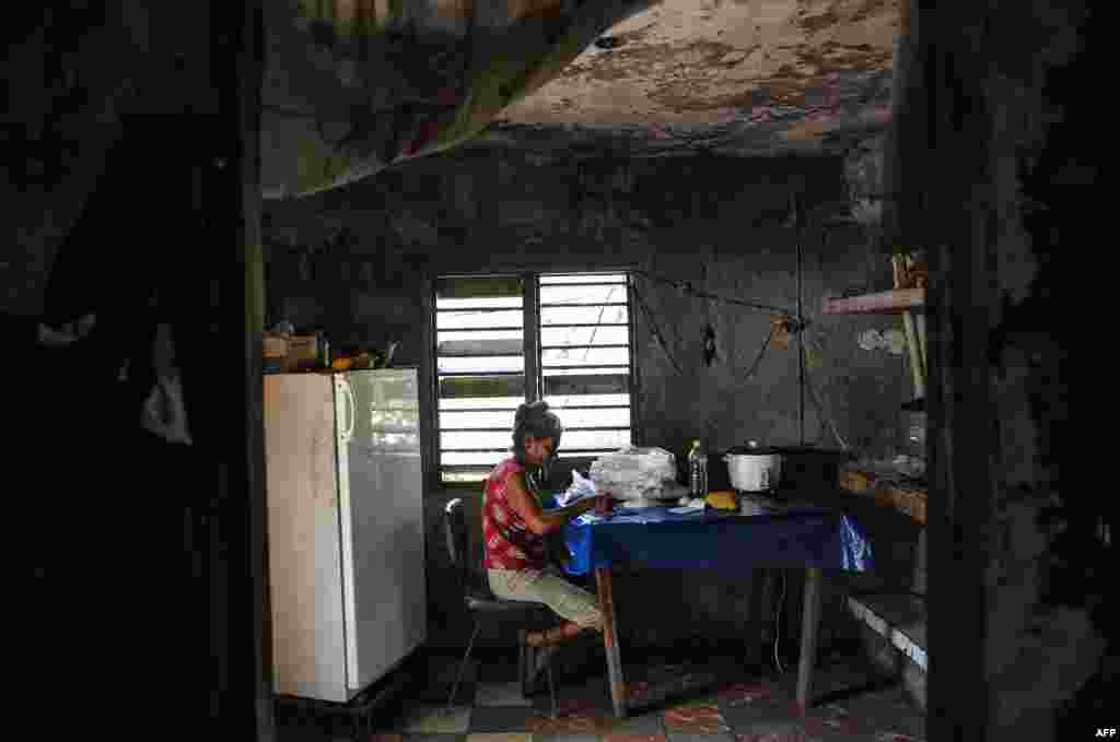 Una señora escoge arroz en su casa en El Caney, Santiago de Cuba el 21 de junio de 2017. YAMIL LAGE / AFP