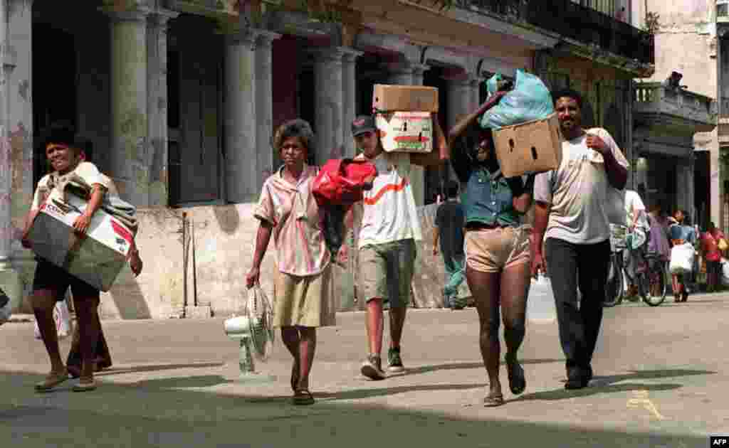 La crisis habitacional en Cuba, según cifras oficiales, requiere casi un millón de viviendas para su solución. Imagen de una familia trasladadando sus pertenencias en La Habana tras el paso de un huracán. Sus hogares corrían peligro de derrumbe. Foto: ADALBERTO ROQUE / AFP
